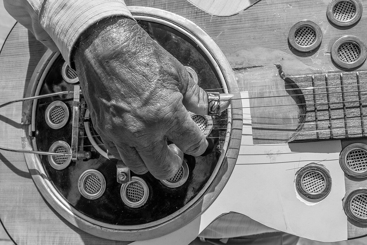 A musician playing an acoustic guitar outdoors